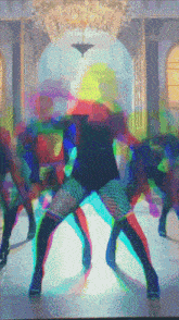 a group of people dancing in a room with a chandelier