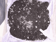 a pile of dirt with white spots on it in a box