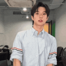 a young man wearing a blue shirt with striped sleeves