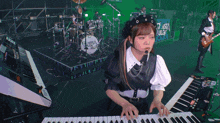 a girl is playing a keyboard in front of a drum set that says " between ruler "