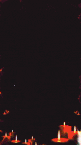 a bunch of candles are lit up in a dark room