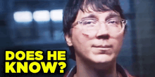 a man with glasses and the words " does he know " on the bottom