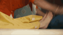 a person wearing yellow gloves is holding a piece of yellow cloth