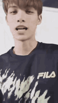a close up of a young man wearing a fila shirt .