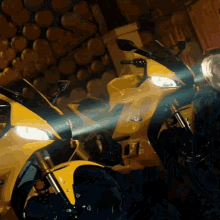two yellow motorcycles are parked next to each other and one of them has the word yamaha on the front