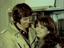 a man and woman are posing for a picture and the woman is smiling
