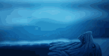 a statue of an octopus is floating on top of a body of water .