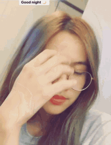 a woman wearing glasses covering her face with her hand and a good night sticker