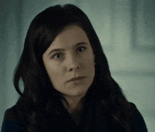 a close up of a woman 's face with dark hair
