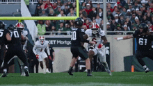 a football player wearing a number 10 jersey is running with the ball