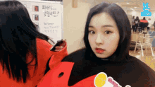 a girl stands in front of a white board with the word vlive on it