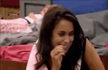 a woman in a pink shirt is smiling and laughing