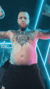 a shirtless man with tattoos on his chest is standing in front of a neon background .