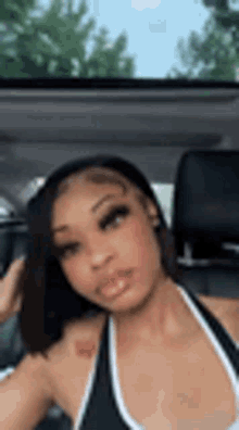 a woman is sitting in a car taking a selfie .
