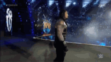 roman reigns is walking out of the ring at a wrestling event
