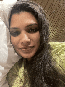 a woman with a nose ring is laying on a bed