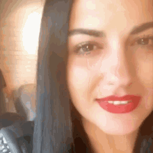 a close up of a woman 's face with red lipstick on her lips
