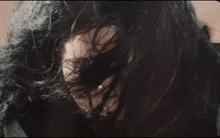a close up of a woman 's face with her eyes closed in a dark room .