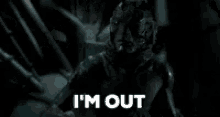 a monster is standing in the dark with the words `` i 'm out '' written on it .
