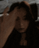 a blurry photo of a woman covering her face with her hand