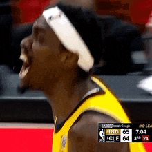 a basketball player wearing a headband screams during a game against the cleveland cavaliers