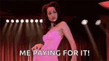 a woman in a pink dress is dancing on a stage with the words `` me paying for it '' .