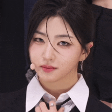 a woman wearing a suit and tie with a microphone in her ear