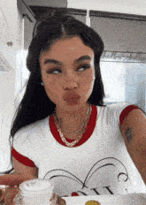 a woman wearing a white t-shirt with a heart on it