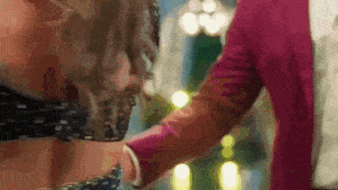 a close up of a woman holding a man 's hand .
