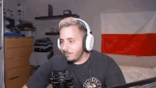 a man wearing headphones is talking into a microphone .