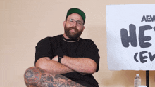 a man sitting in front of a sign that says aew he 's crew