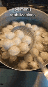 a pot of pelmeni is being stirred with a spoon and the words pelmenis stabilizacions are above it