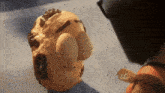 a close up of a puppet 's face with a man 's head in the background