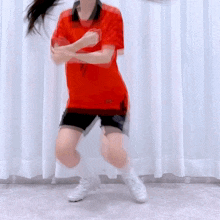 a woman in a red shirt with the number 7 on it is squatting down