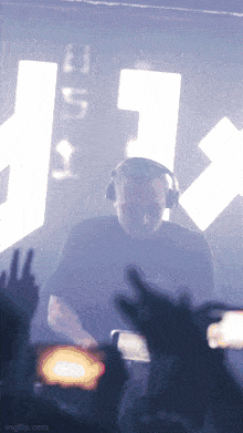 a man wearing headphones is playing a dj set in front of a sign that says edda