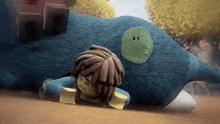 a cartoon character is laying on the ground with a green object on her back