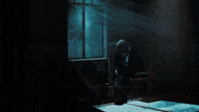 a man is sitting in a chair in a dark room