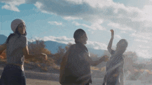 a group of young women are standing on a desert road holding hands