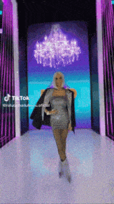 a woman in a silver dress is standing in front of a purple chandelier