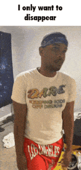 a man wearing a dare shirt and red shorts is standing in a room