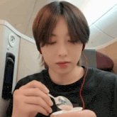 a young man is holding a spoon in his hand and looking down