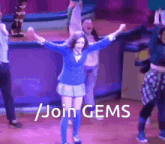 a group of people are dancing on a stage with the words " join gems " written on the bottom
