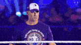 a wrestler wearing a purple shirt that says the last time is now