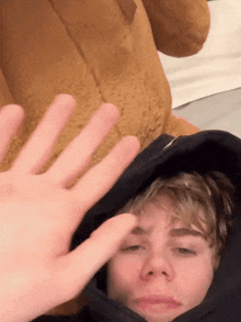 a person is putting their hand on a man 's head