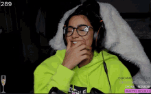 a woman wearing headphones and a neon green hoodie with the number 289 on the top left