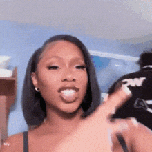 a woman is making a funny face and sticking her tongue out while giving a peace sign .
