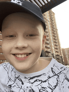 a young boy wearing a hat with the letter a on it smiles for the camera