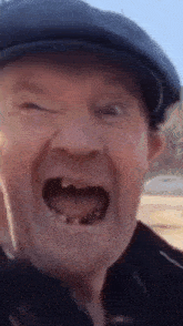 a man with no teeth wearing a hat is making a funny face