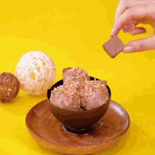 a person is dipping a waffle in a bowl of chocolate ice cream