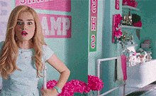 a girl is standing in a room with a sign on the wall that says amp .